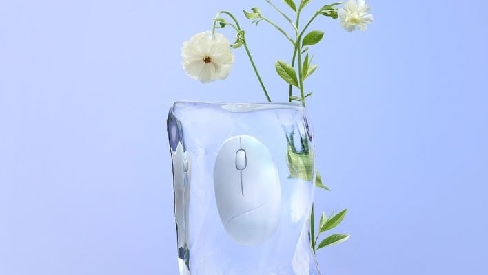 꽃 옆에 얼음처럼 생긴 케이스 안에 들어 있는 ASUS Fragrance Mouse.